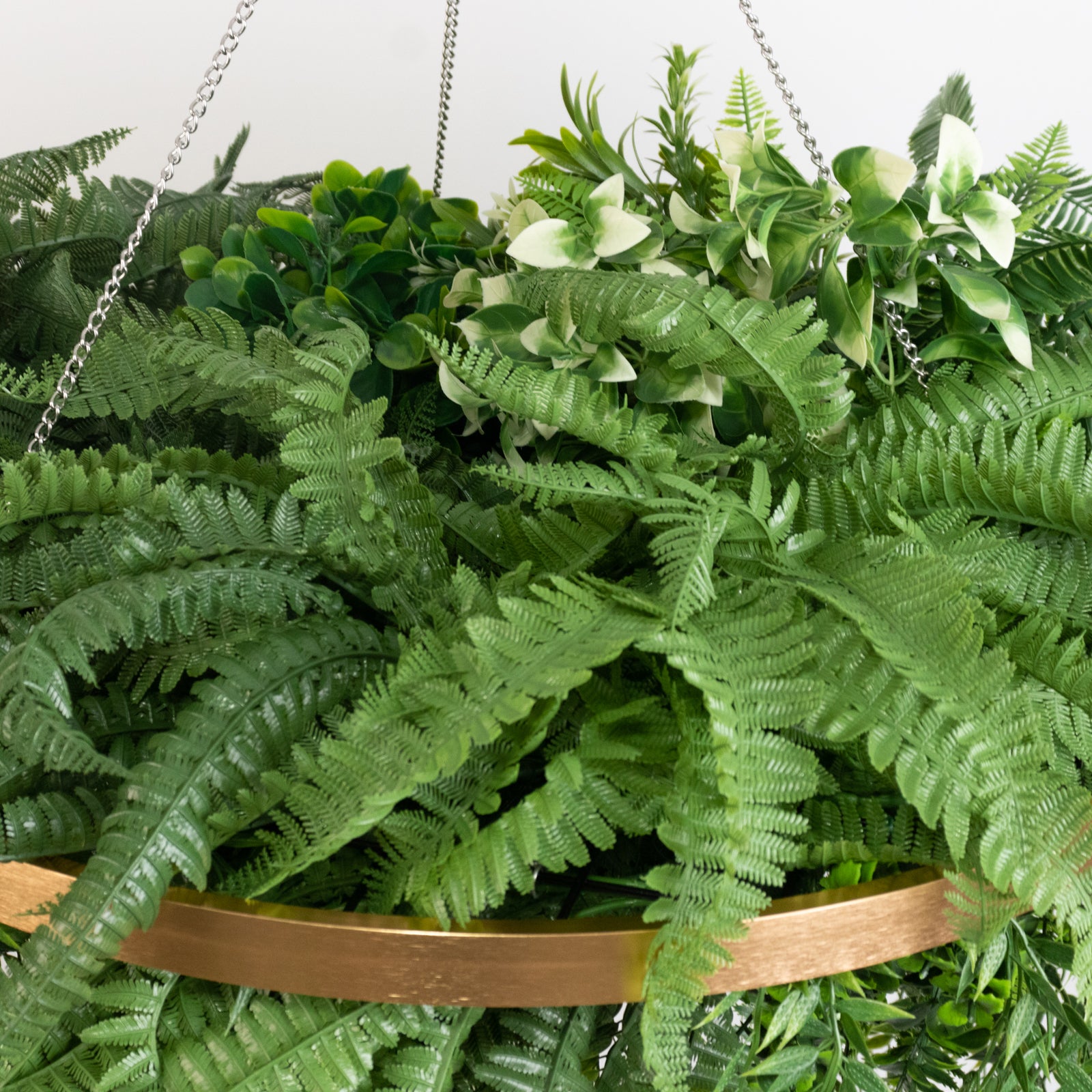 Large faux greenery hoop chandelier with gold ring and lush green ferns.