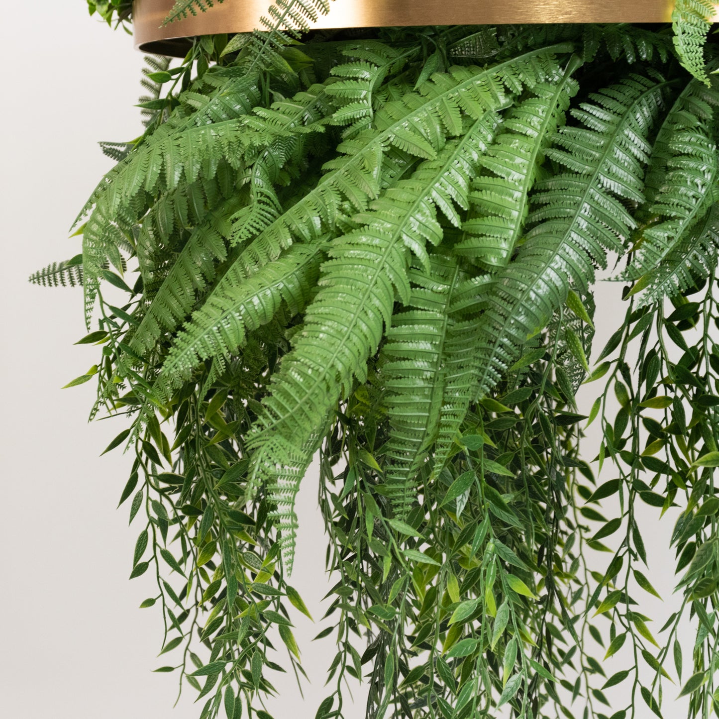 Large faux greenery hoop chandelier with gold ring and draping greenery.
