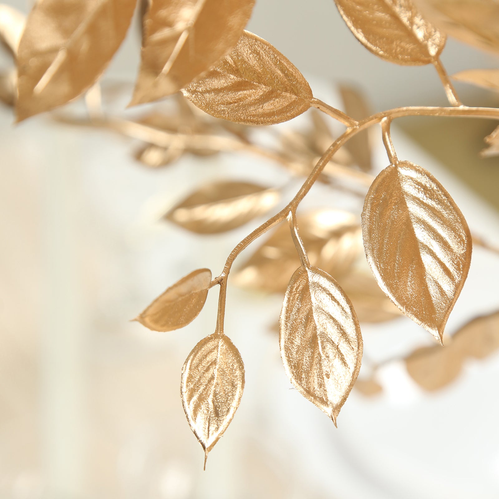 Gold metallic artificial leaf spray for decorative arrangements.