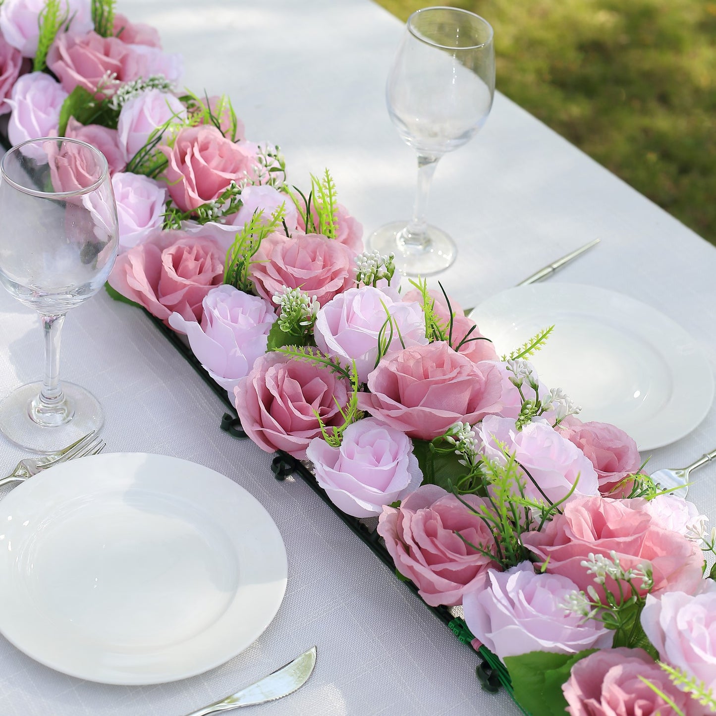 Dusty rose silk flower table runner with artificial floral arrangements.