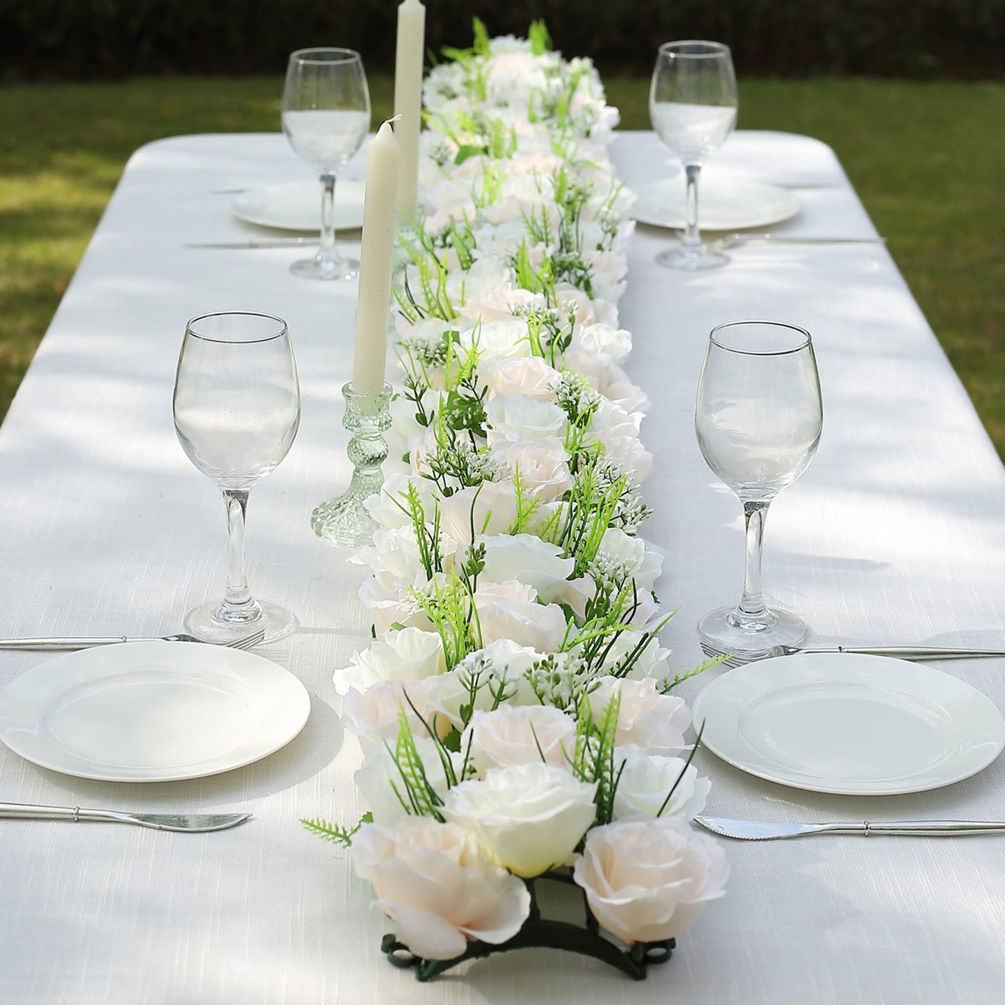 Cream ivory silk rose flower table runner with greenery centerpiece.