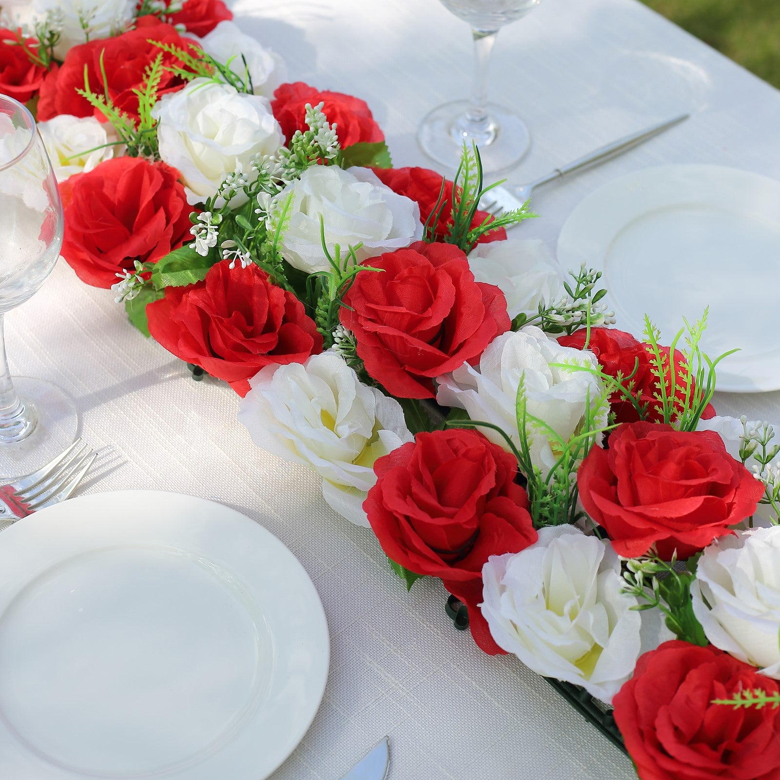 Red and white artificial silk rose flower table runner centerpiece.