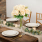 Cream artificial silk rose bouquet with long stems in a decorative arrangement.