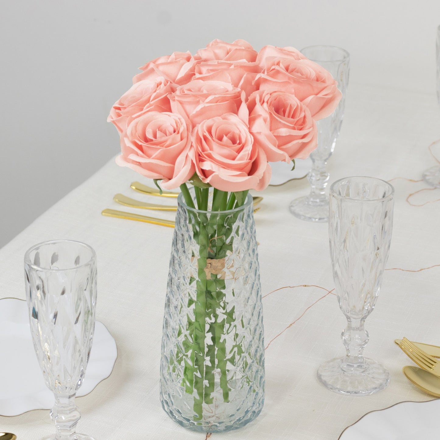 Pink artificial silk roses in a vase for floral arrangements.