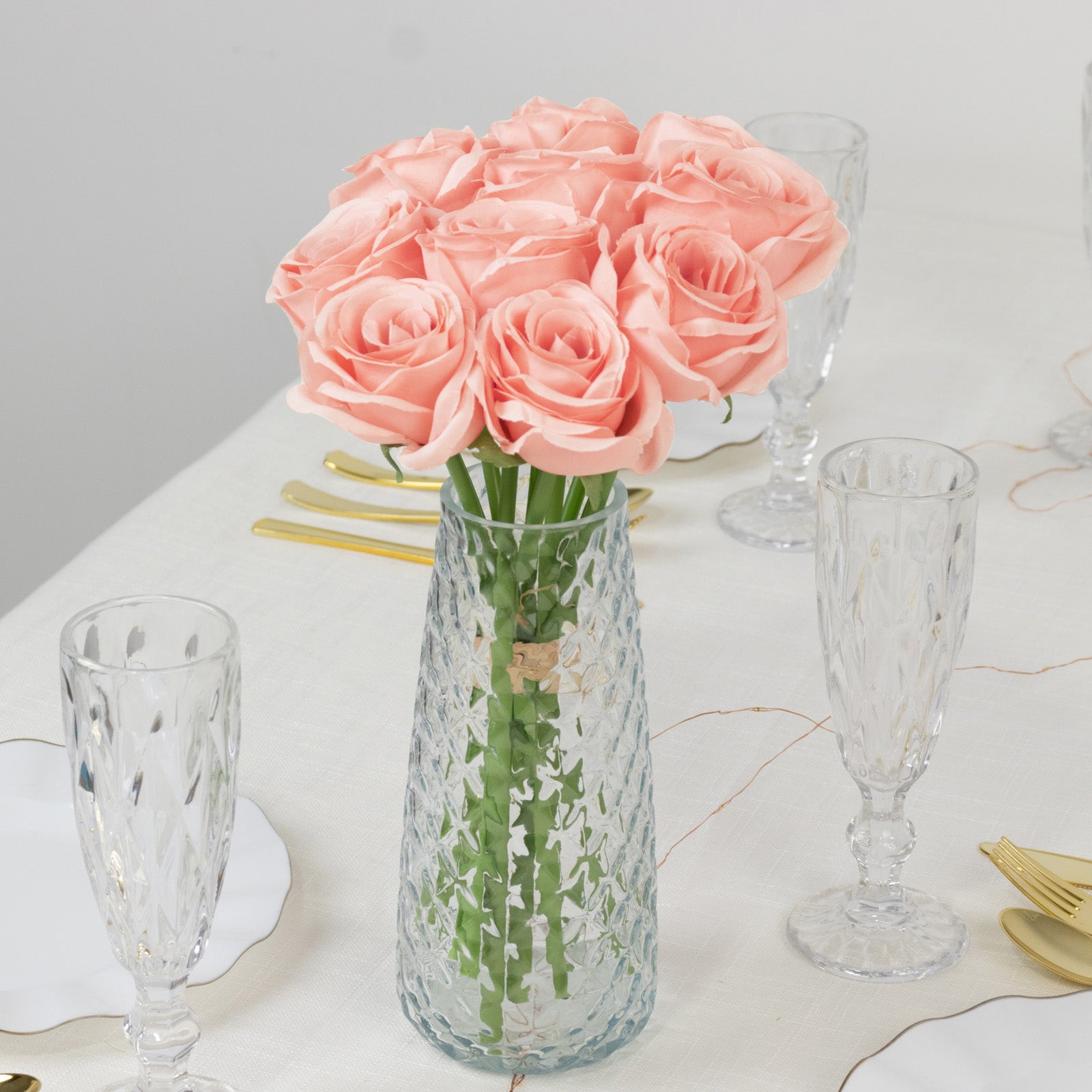 Pink artificial silk roses in a vase for floral arrangements.
