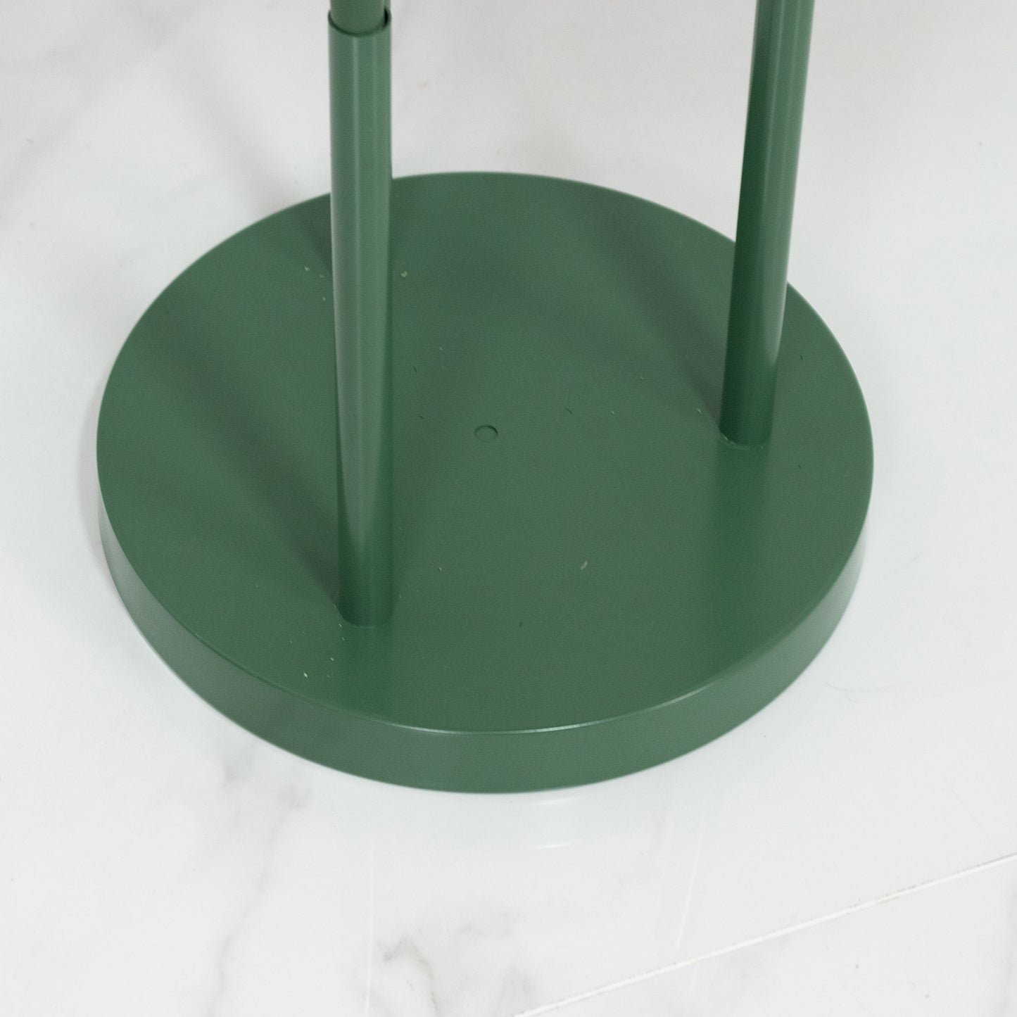 Green base for giant red artificial roses in a standing arrangement.