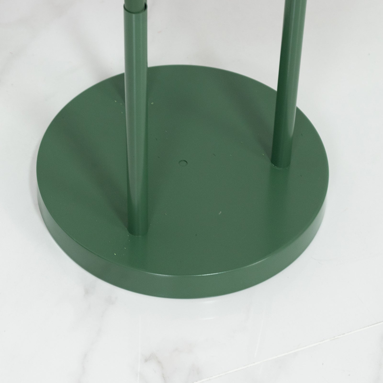 Green base for giant red artificial roses in a standing arrangement.