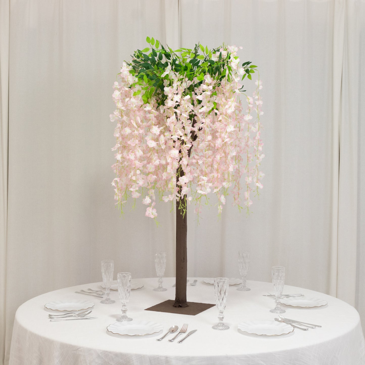 Blush artificial wisteria tree centerpiece with cascading silk flowers.