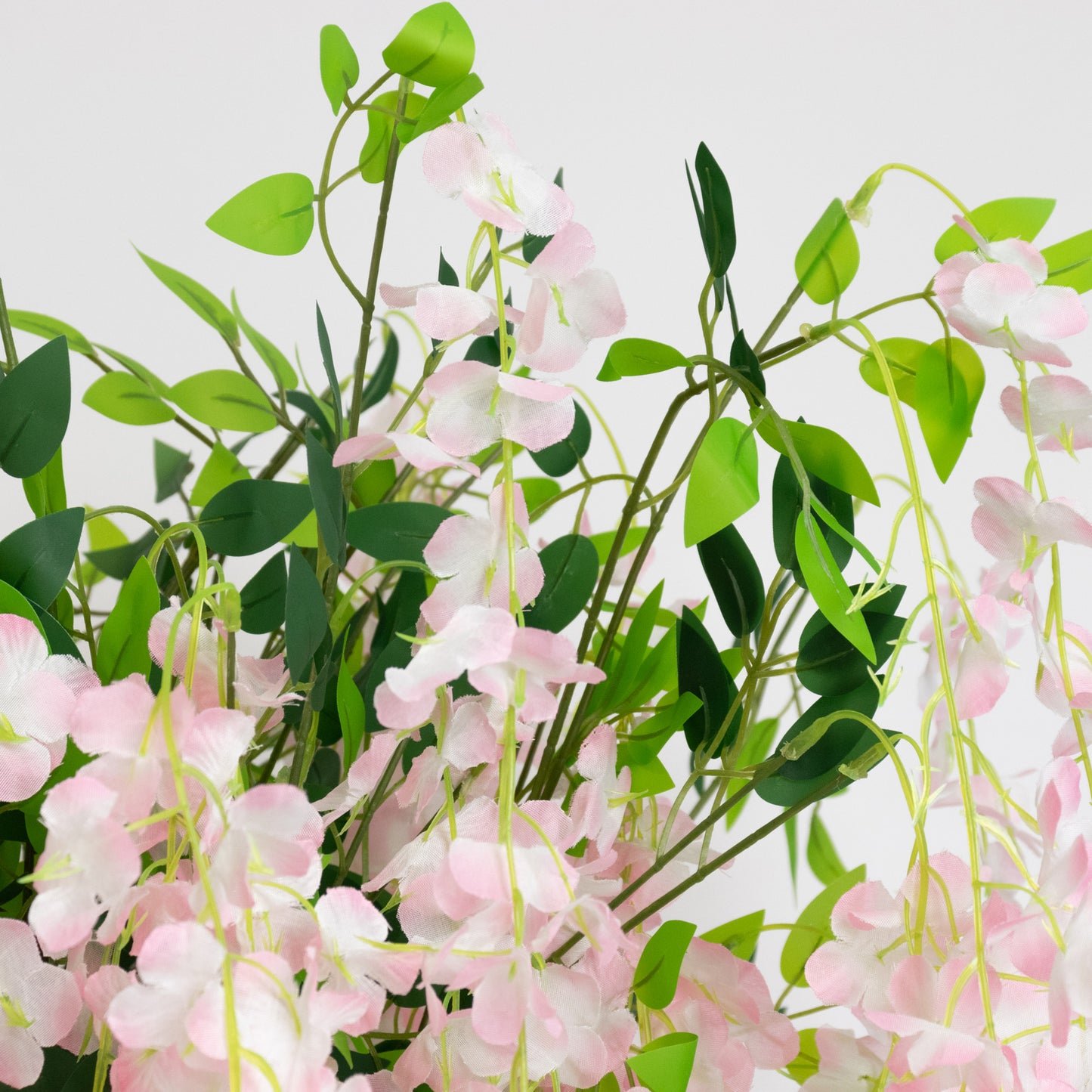 Blush artificial wisteria tree with cascading silk flowers and natural trunk.