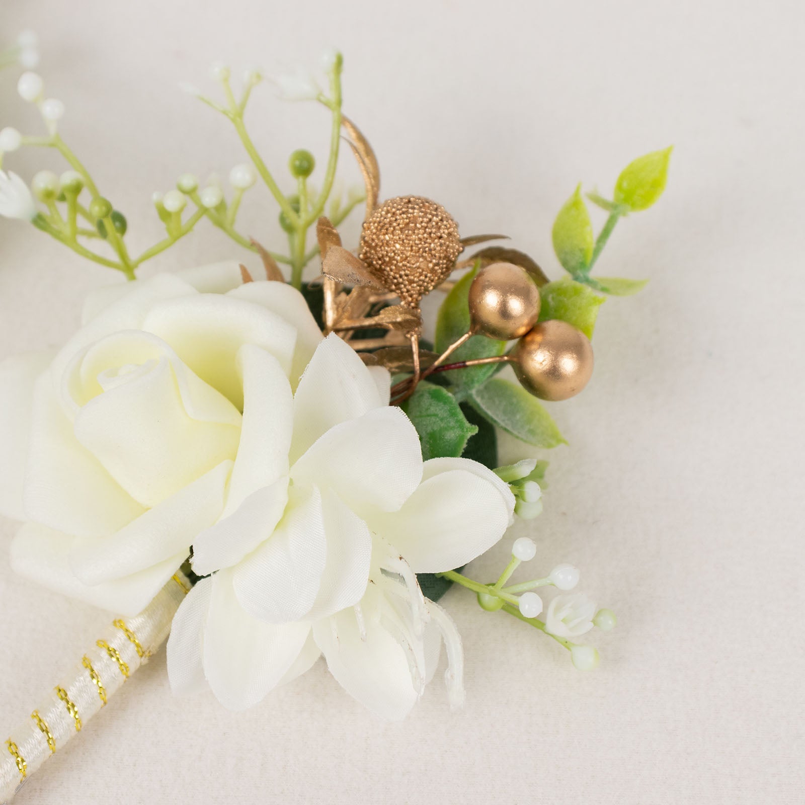 White artificial rose boutonniere with pin and greenery accents.