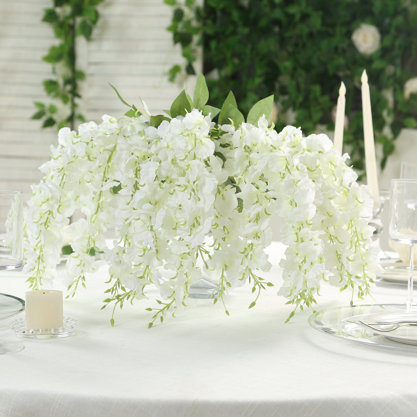 Cream silk wisteria vines hanging plants in a lush white arrangement.