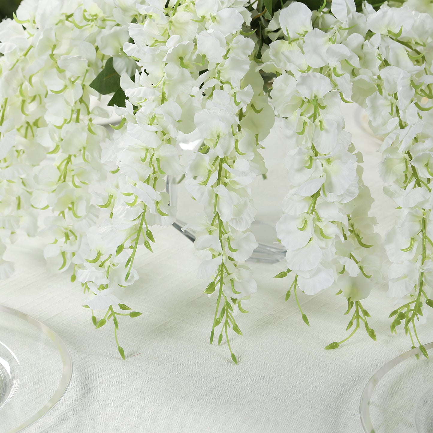 White hanging wisteria vines with green accents in a decorative arrangement.