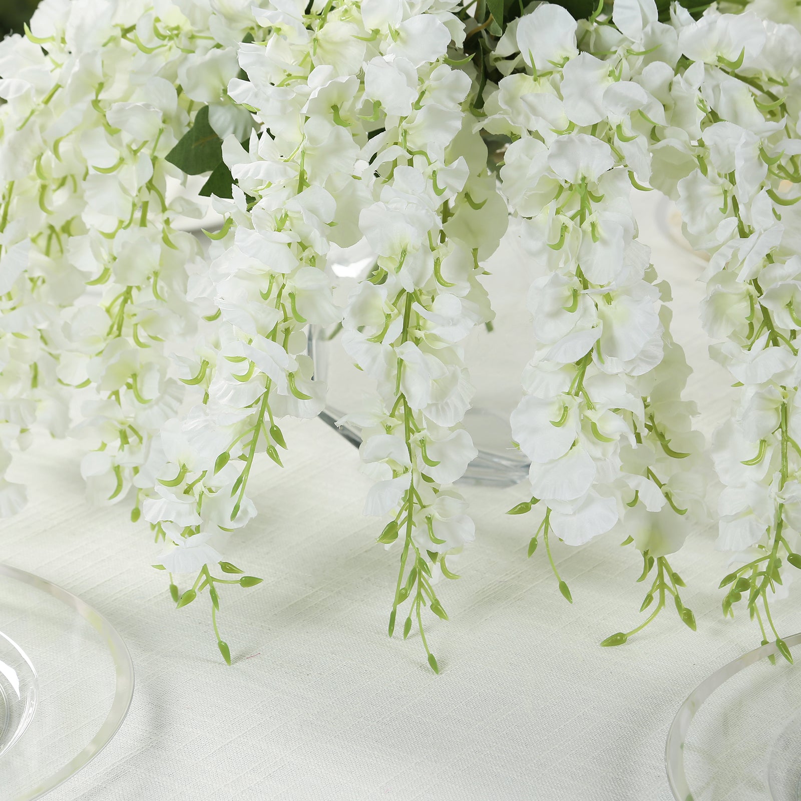 White hanging wisteria vines with green accents in a decorative arrangement.