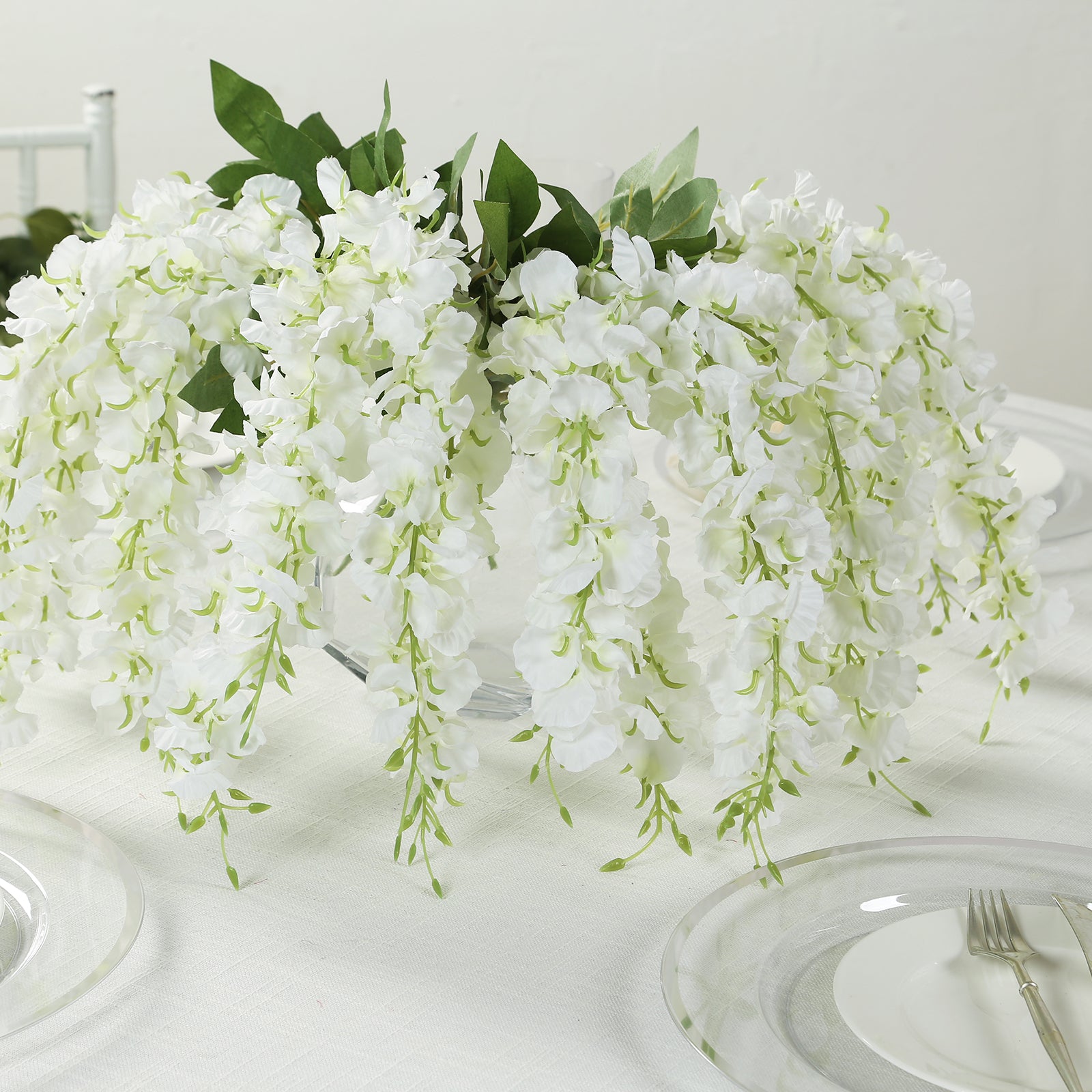 White cream silk wisteria vines hanging plants, elegant floral centerpiece.