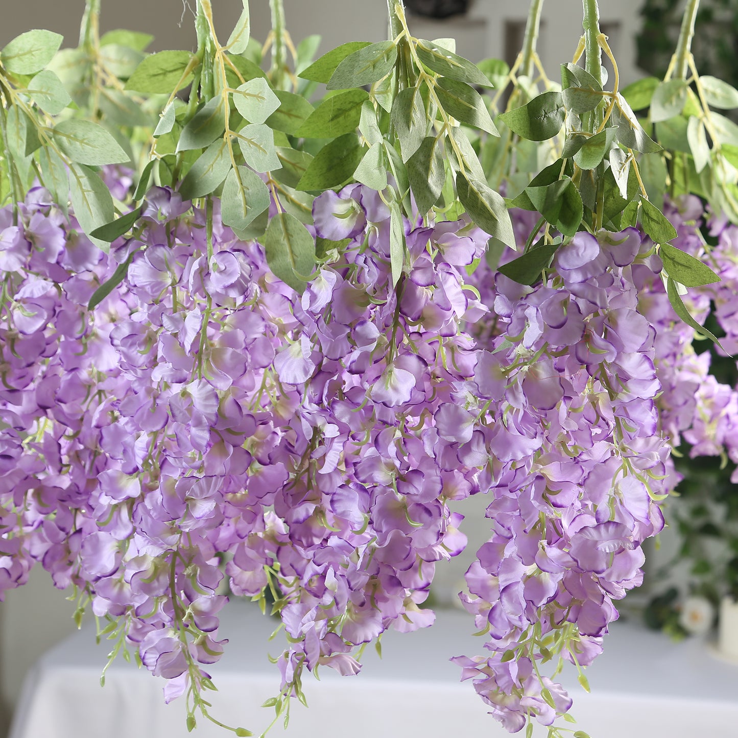 Purple silk wisteria vines hanging plants with long artificial flowers.