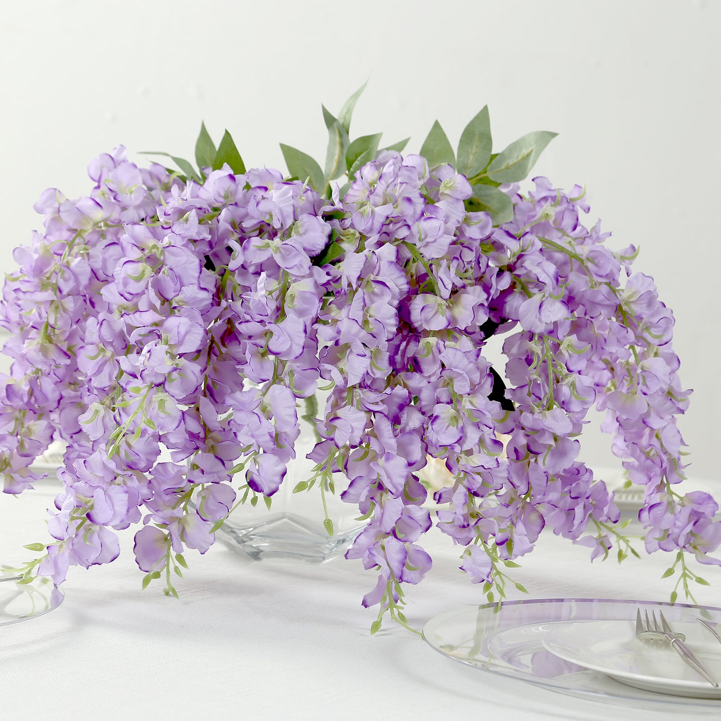 Purple silk wisteria vines in a decorative arrangement, 21 inches long.