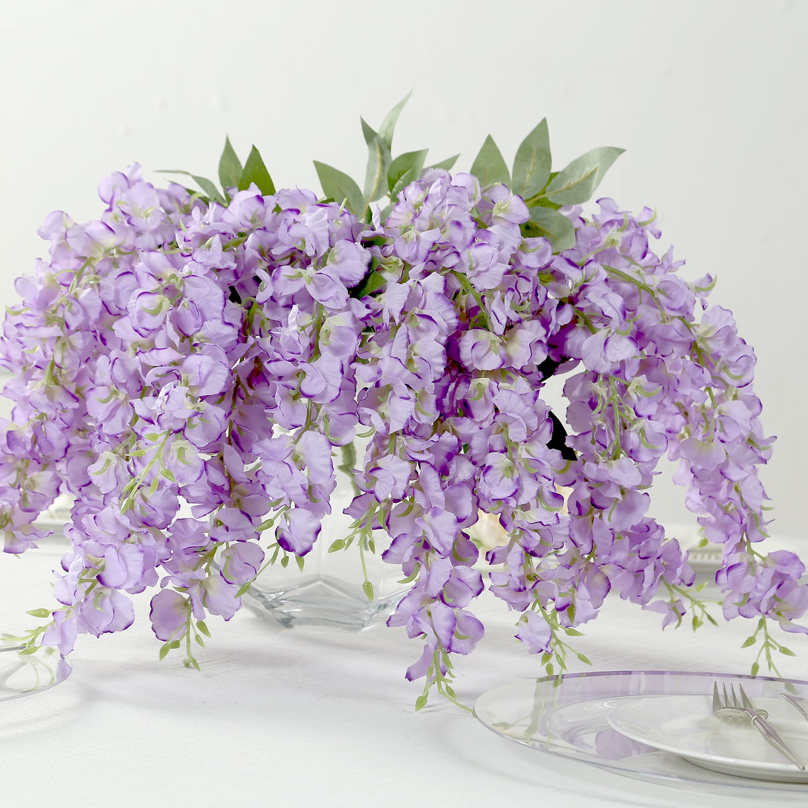 Purple silk wisteria vines in a decorative arrangement, 21 inches long.