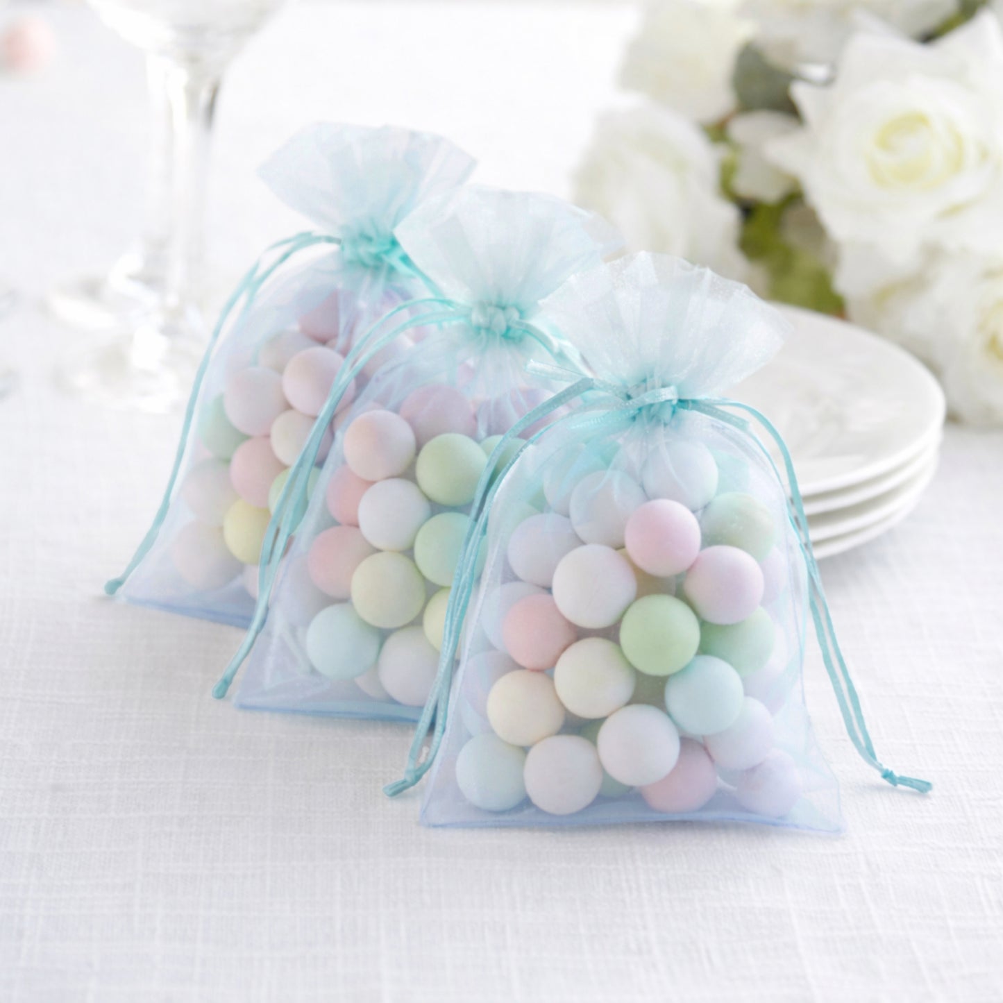 Light blue organza gift bags with drawstring, perfect for wedding favors.