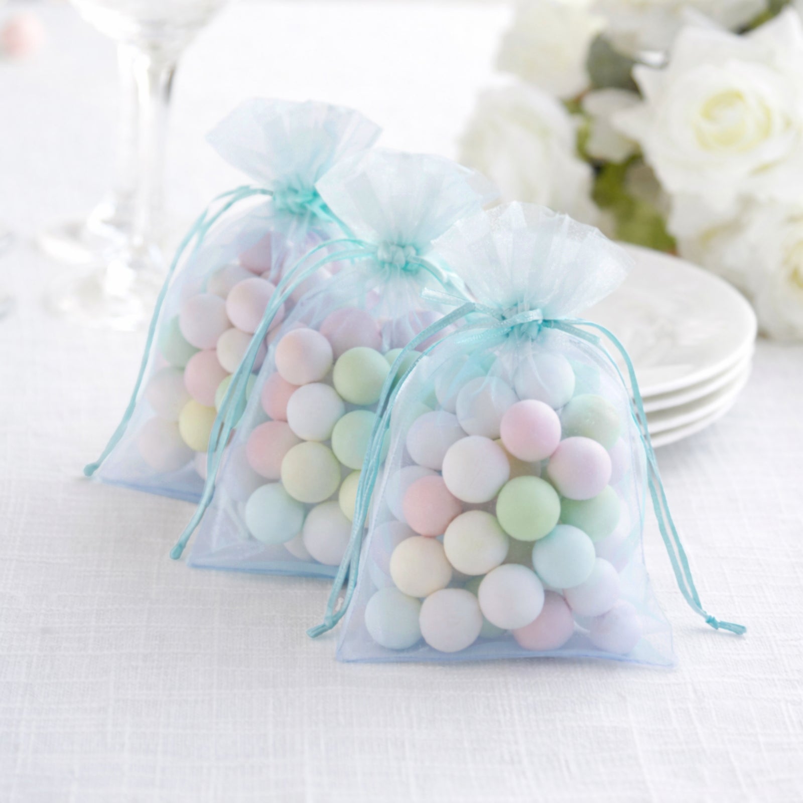 Light blue organza gift bags with drawstring, perfect for wedding favors.