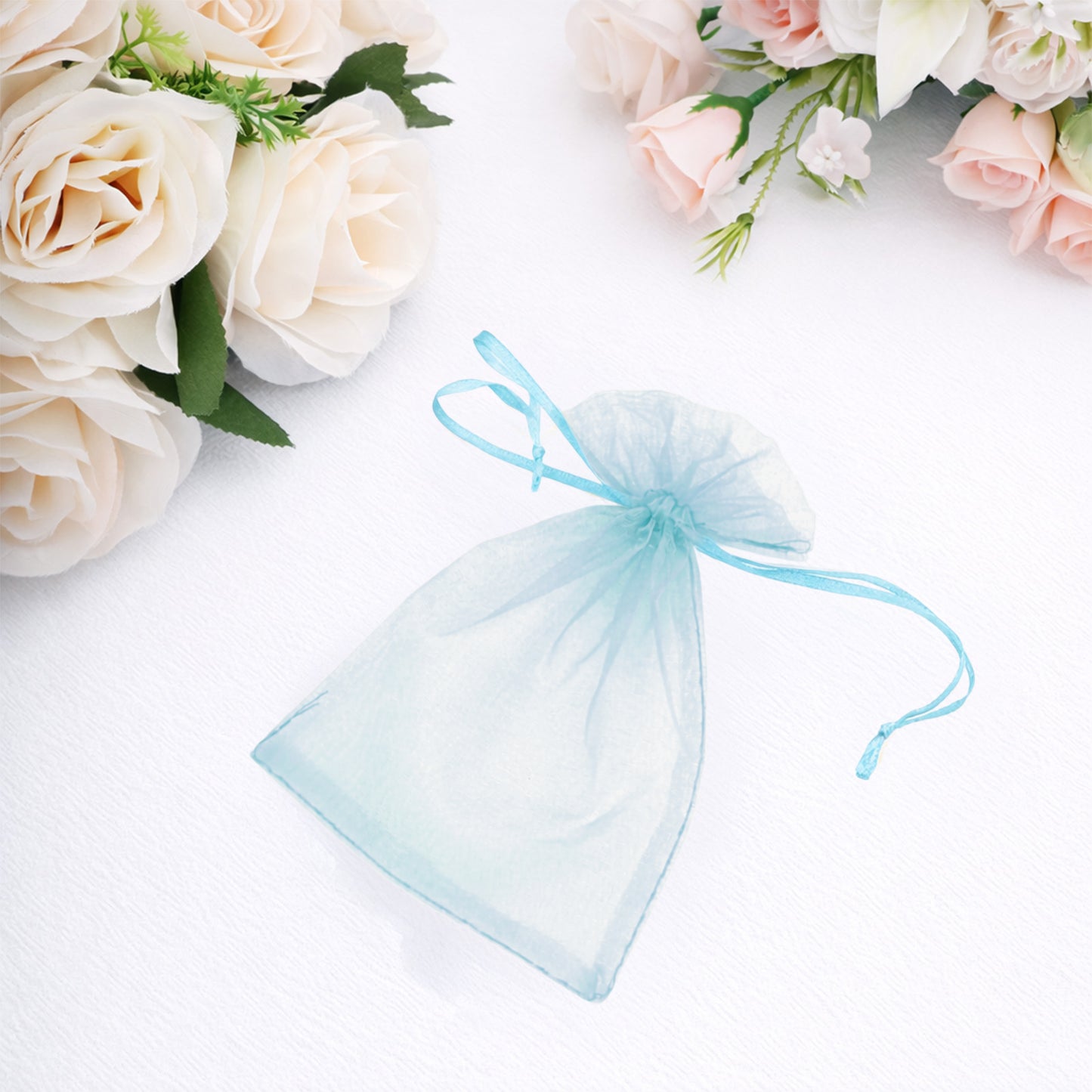 Light blue organza gift bag with drawstring, 4" x 6", ideal for weddings.