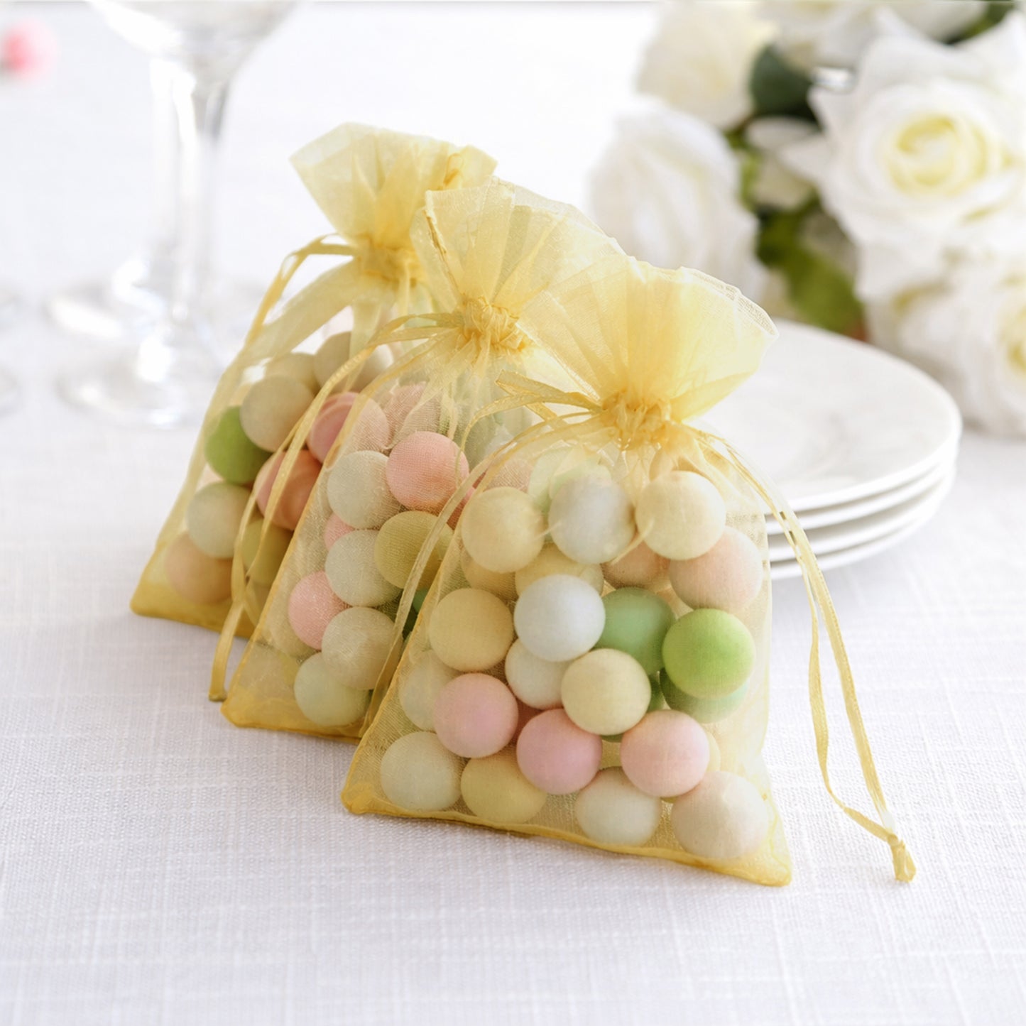 Gold organza gift bags filled with colorful candies, perfect for party favors.