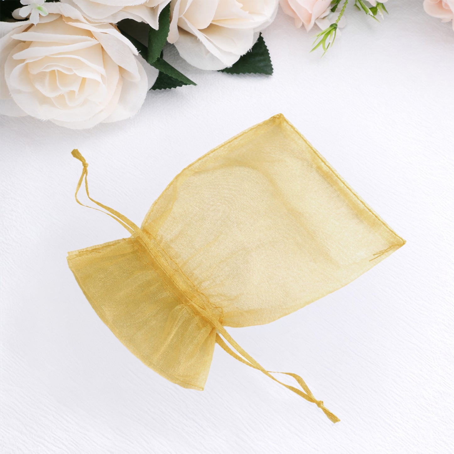 Gold organza gift bag with drawstring, perfect for wedding favors.