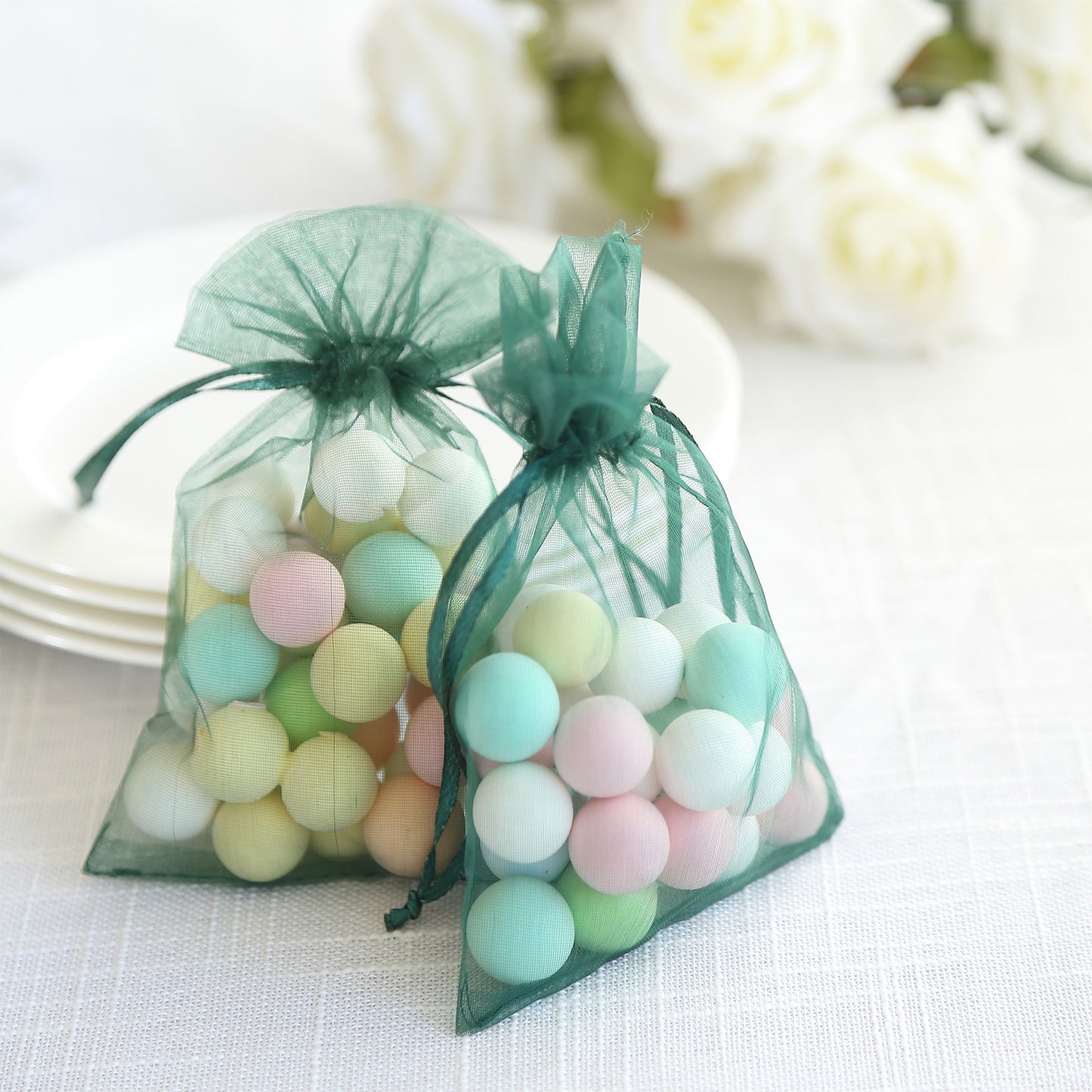 Emerald green organza gift bags filled with colorful decorative balls.