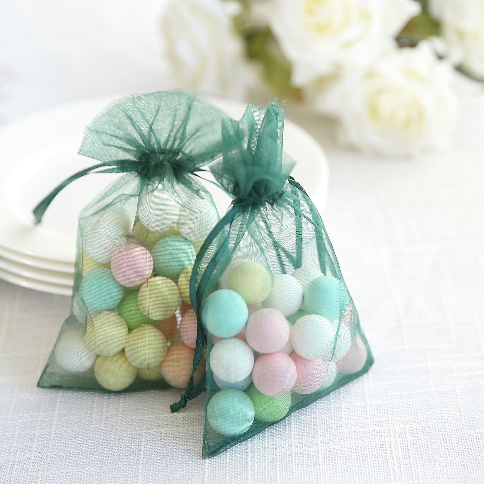 Emerald green organza gift bags filled with colorful decorative balls.