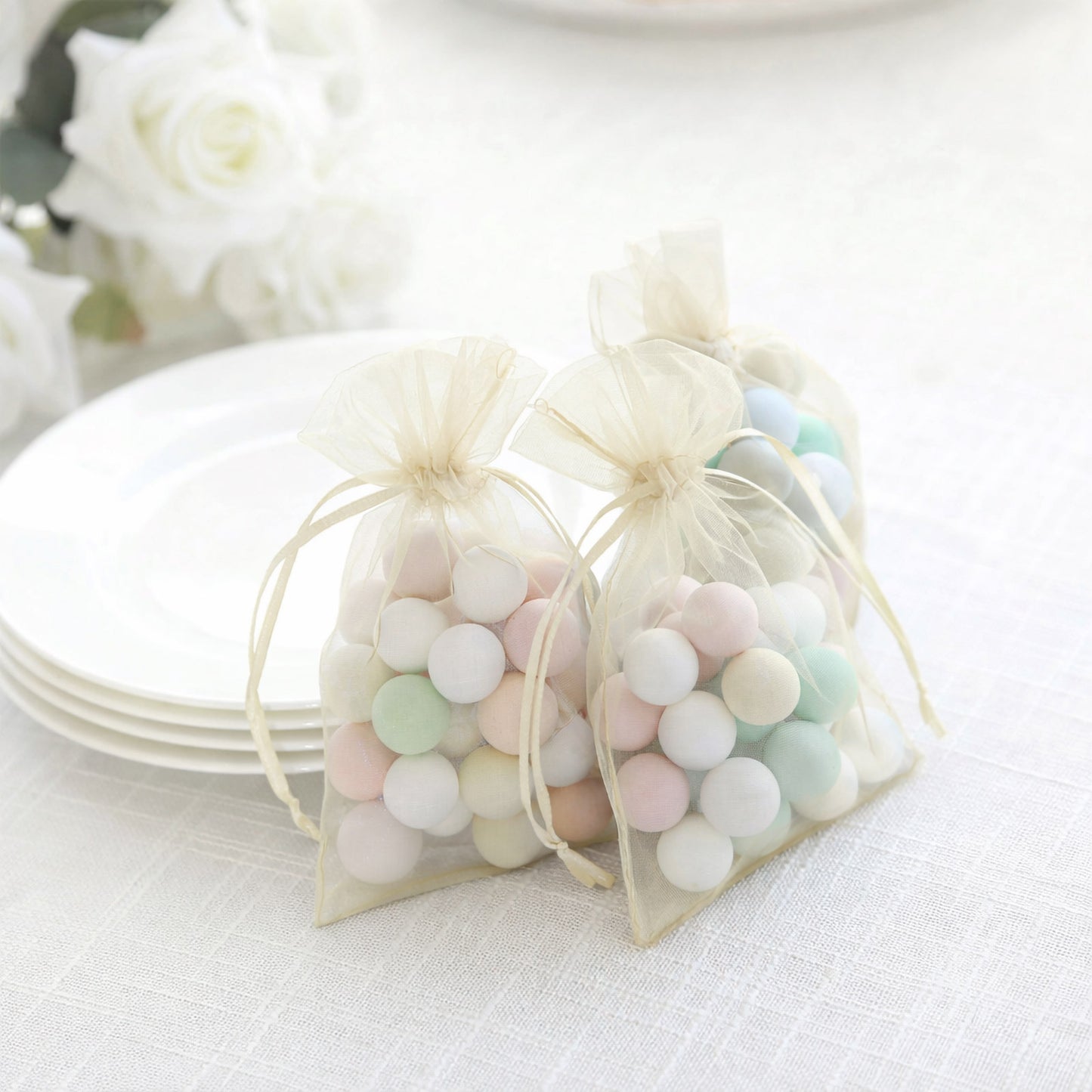 Ivory organza gift bags with drawstring, perfect for wedding favors.