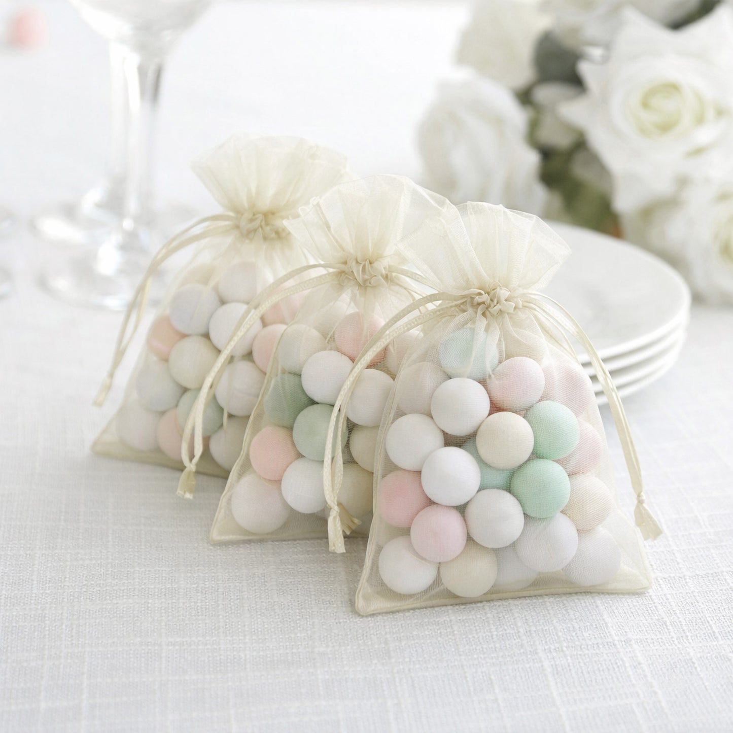 Ivory organza gift bags with drawstring, perfect for wedding favors.