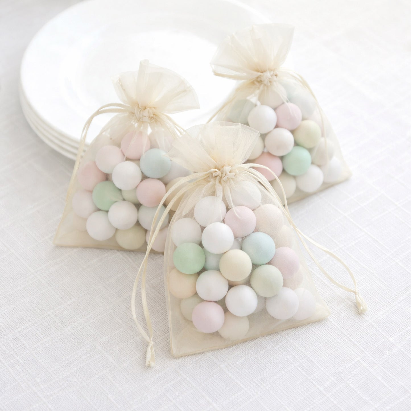 Ivory organza gift bags with drawstring, perfect for wedding favors.