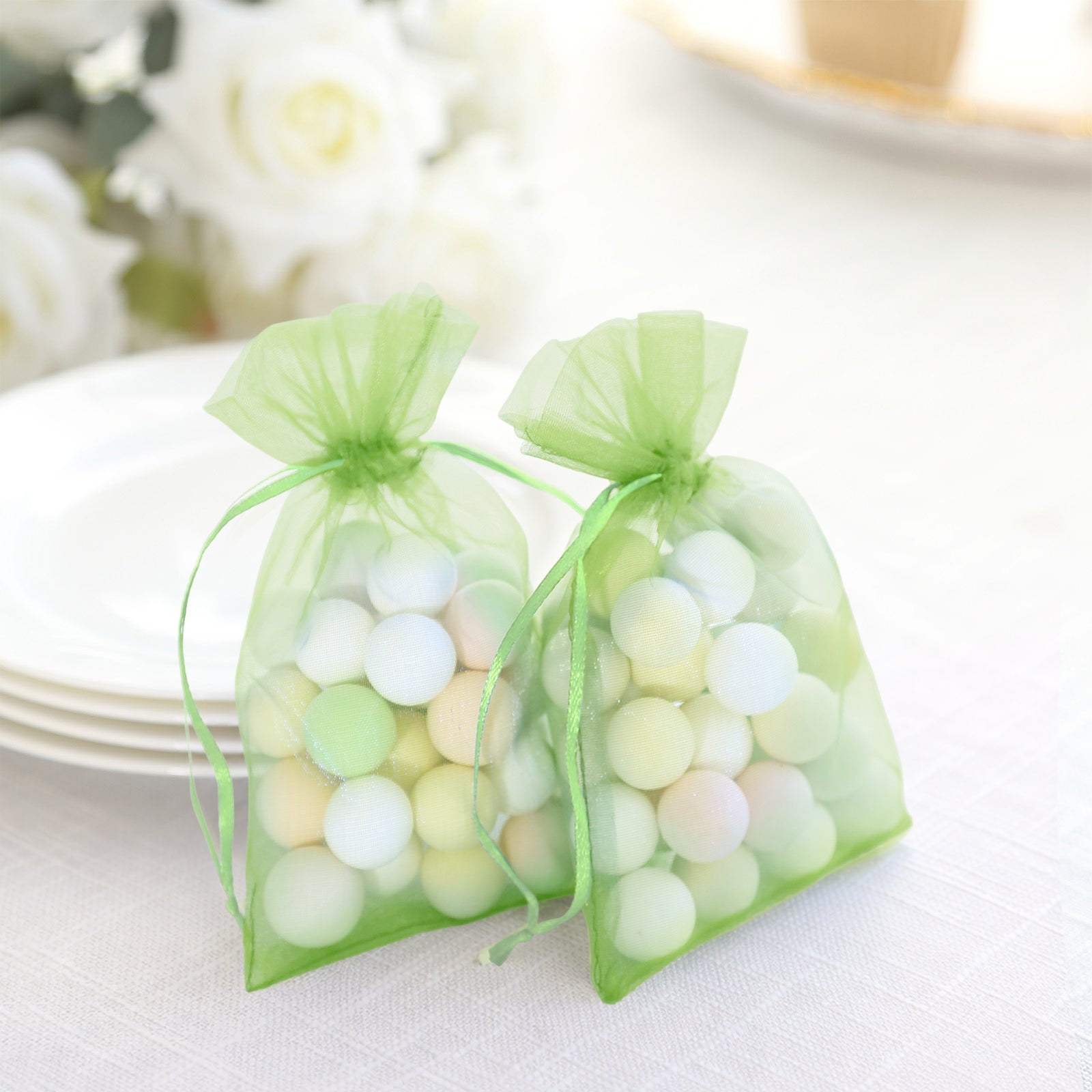 Mint organza gift bags with drawstring, filled with colorful balls.