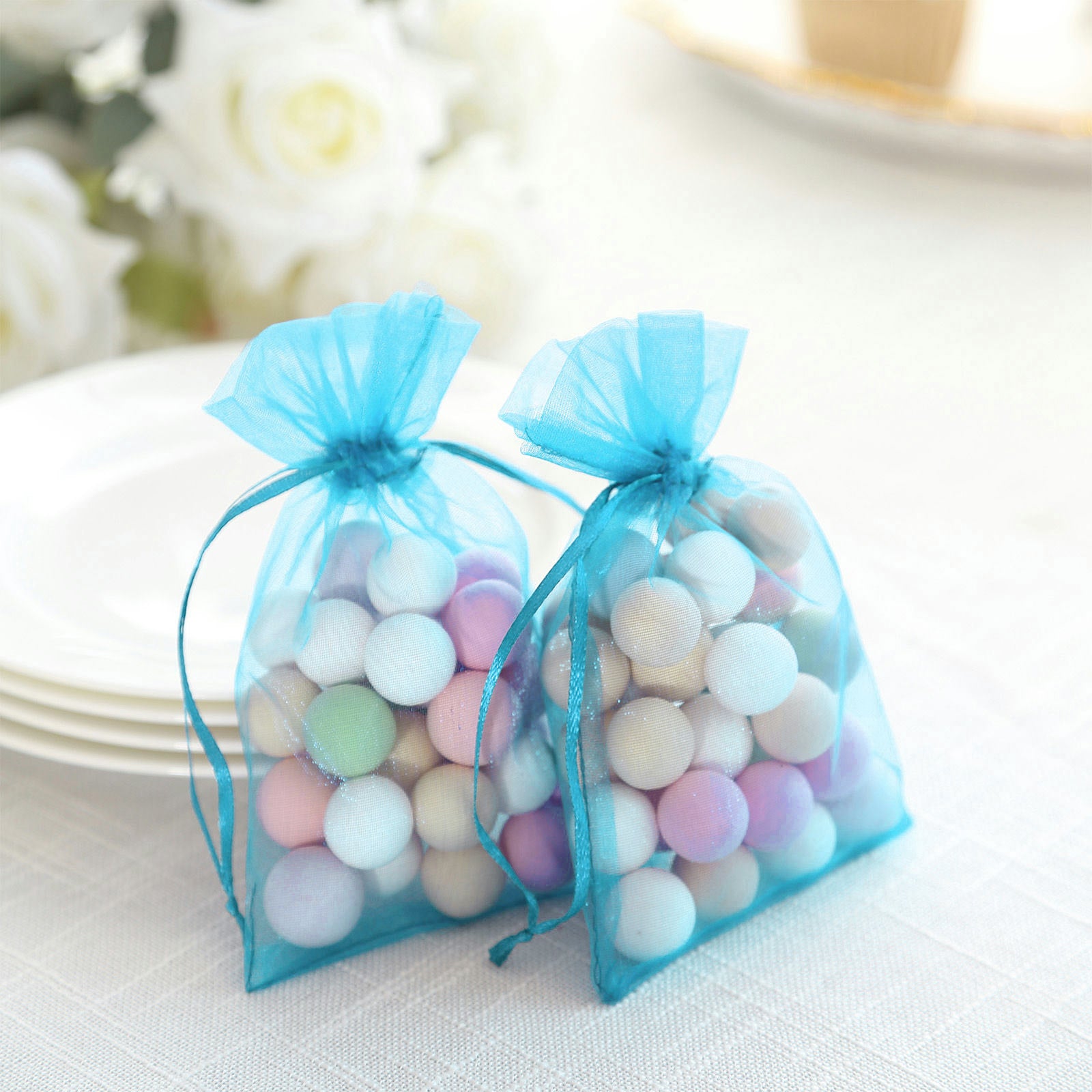 Turquoise organza gift bags filled with colorful decorative balls.