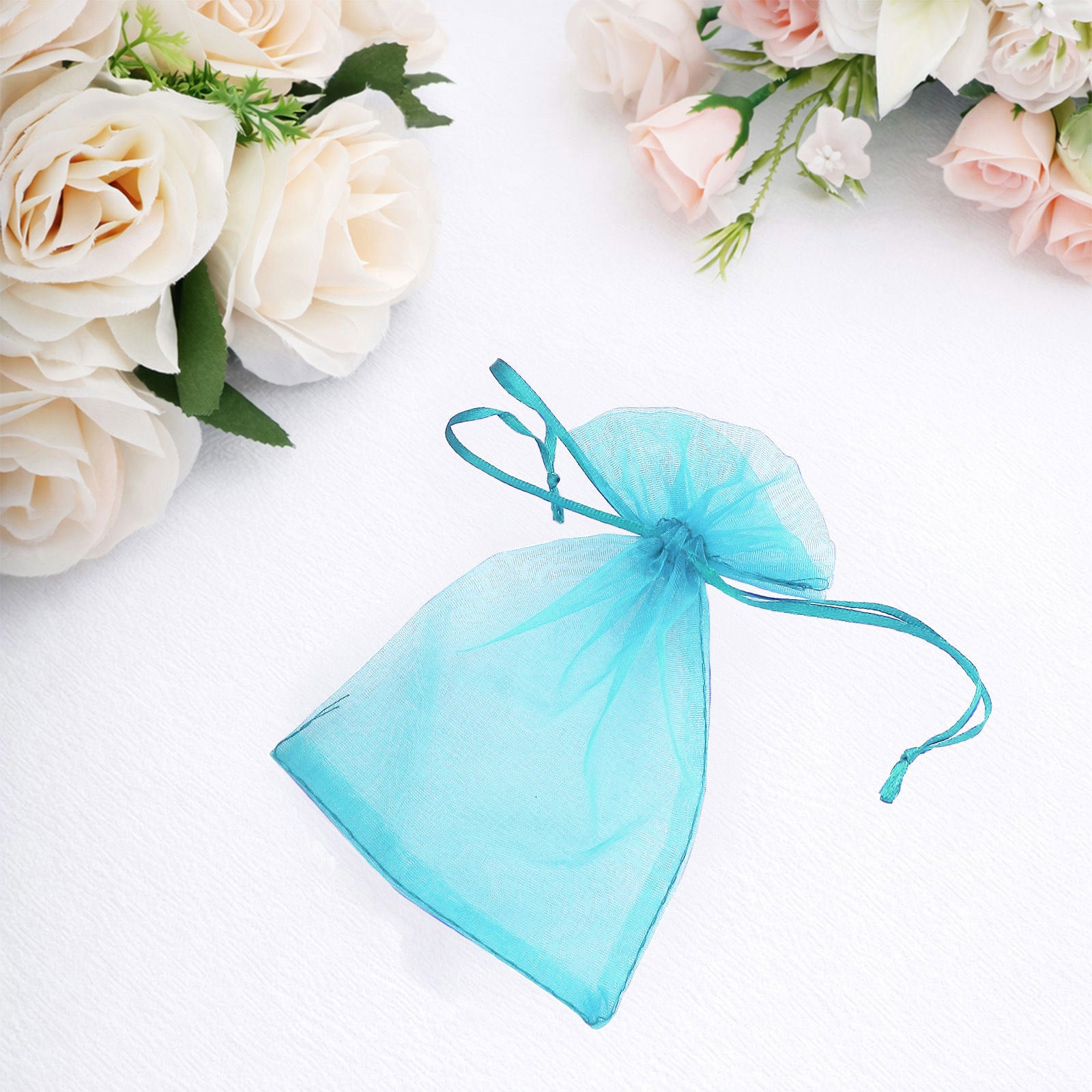Turquoise organza gift bag with drawstring, 4" x 6", perfect for party favors.