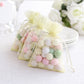 Yellow organza gift bags with drawstring filled with colorful candies.