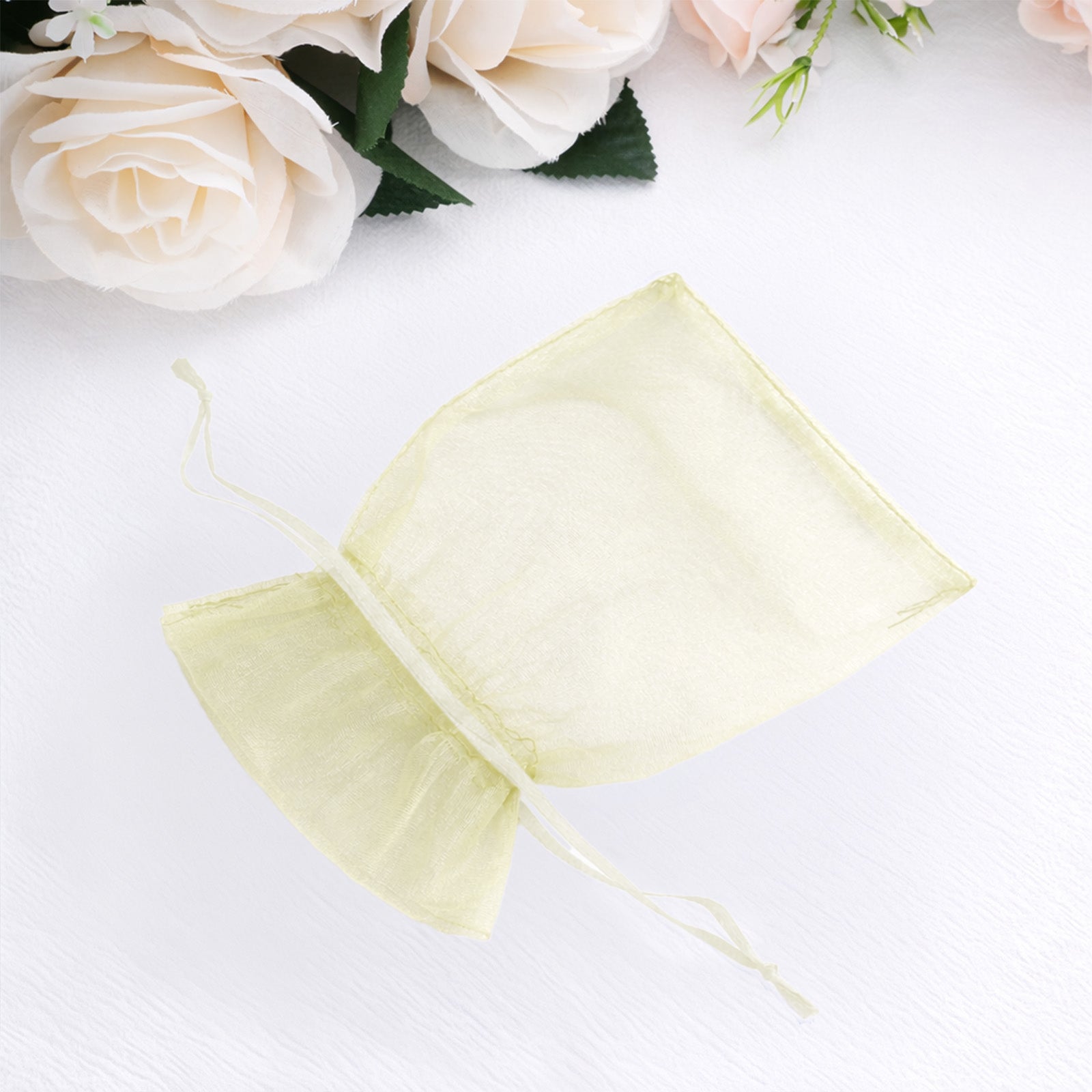 Yellow organza gift bag with drawstring, perfect for wedding favors.