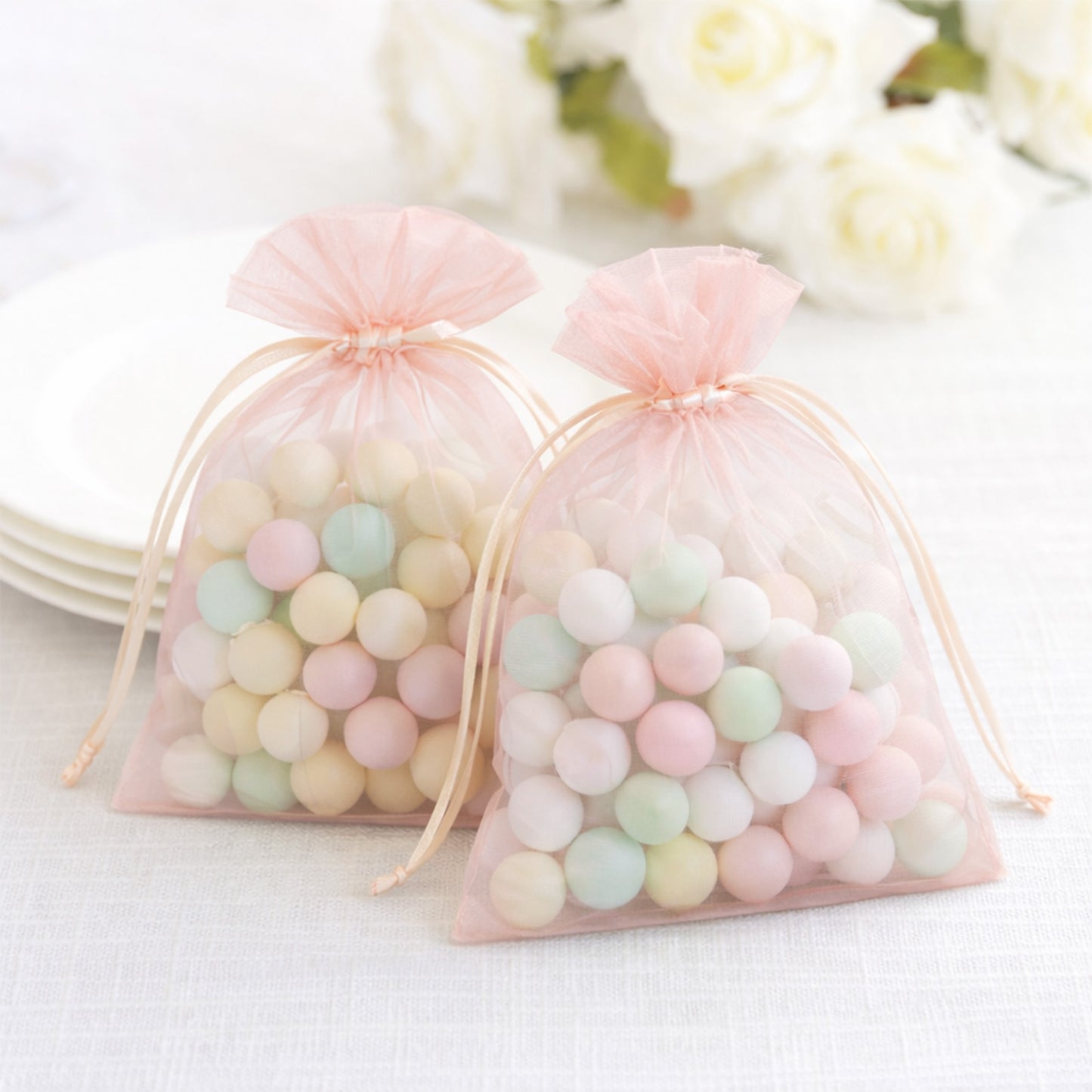 Blush organza gift bags with drawstring, perfect for wedding favors.
