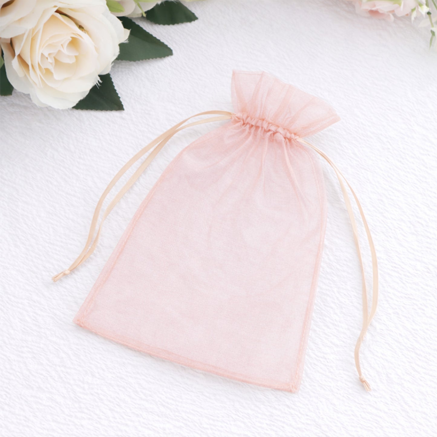 Blush organza gift bag with drawstring, 5" x 7" for wedding favors.