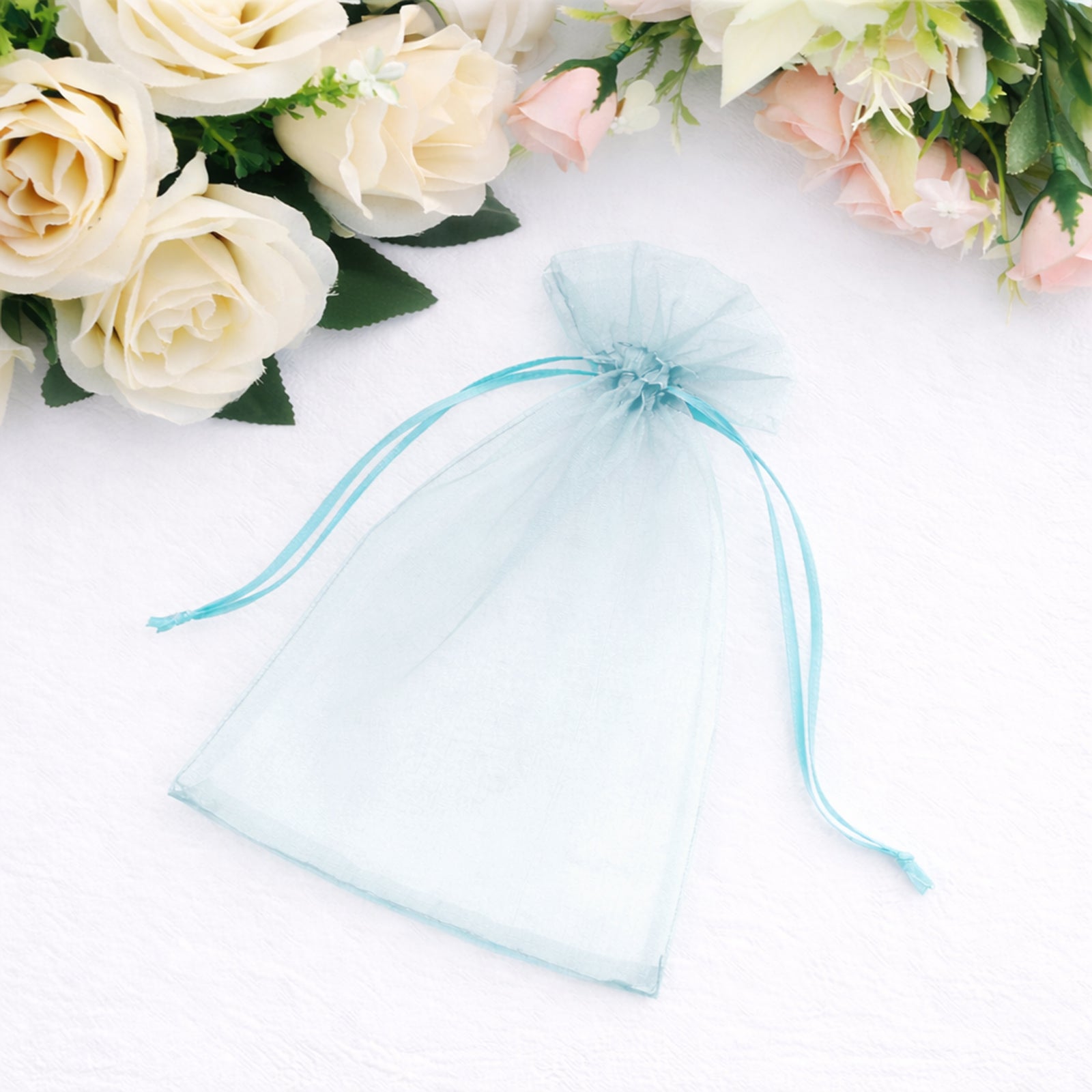 Light blue organza gift bag with drawstring, perfect for wedding favors.