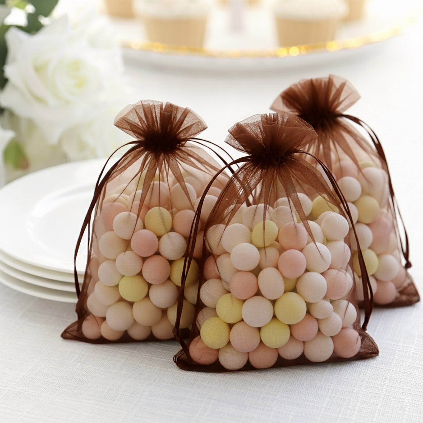 Brown chocolate organza gift bags filled with pastel candies.