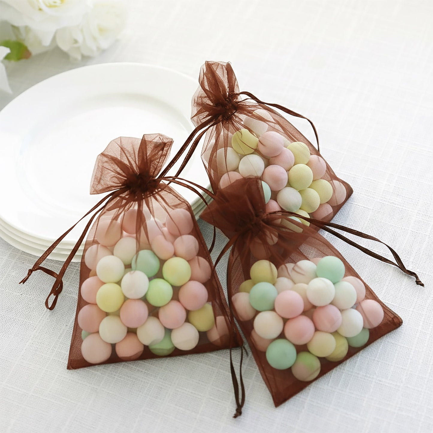 Chocolate organza gift bags filled with pastel candies, perfect for parties.
