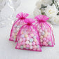 Fuchsia organza gift bags with drawstring, perfect for wedding favors.