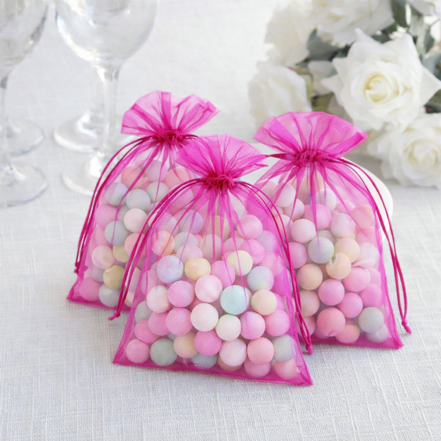 Fuchsia organza gift bags with drawstring, perfect for wedding favors.