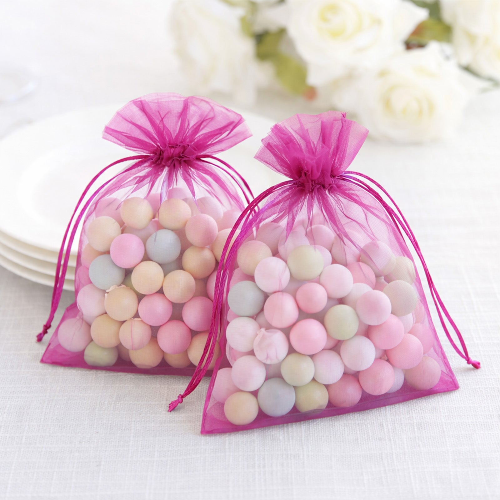 Fuchsia organza gift bags with drawstring, perfect for wedding favors.
