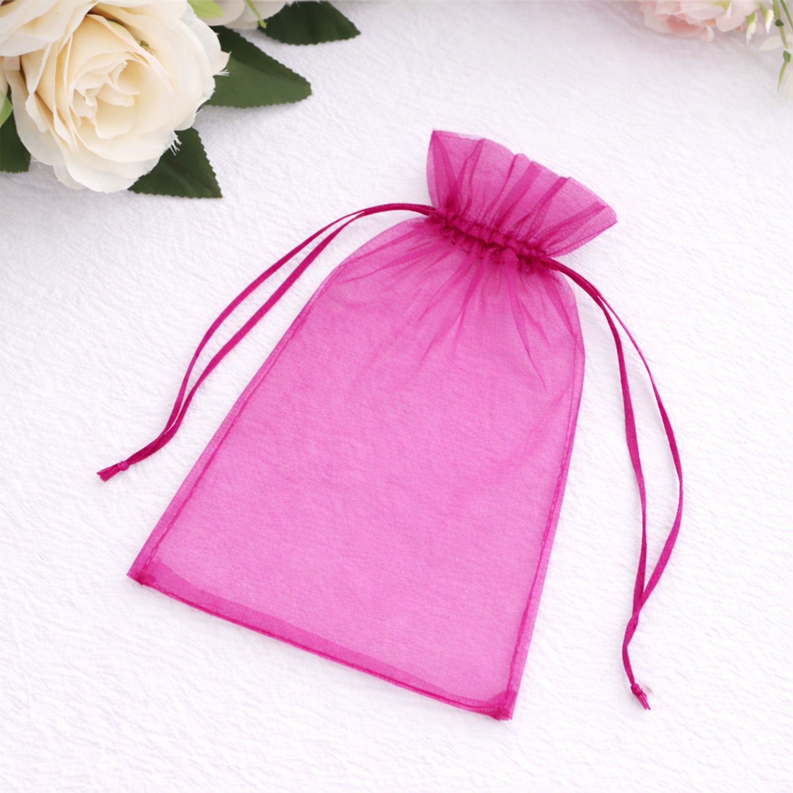 Fuchsia organza gift bag with drawstring, perfect for wedding favors.