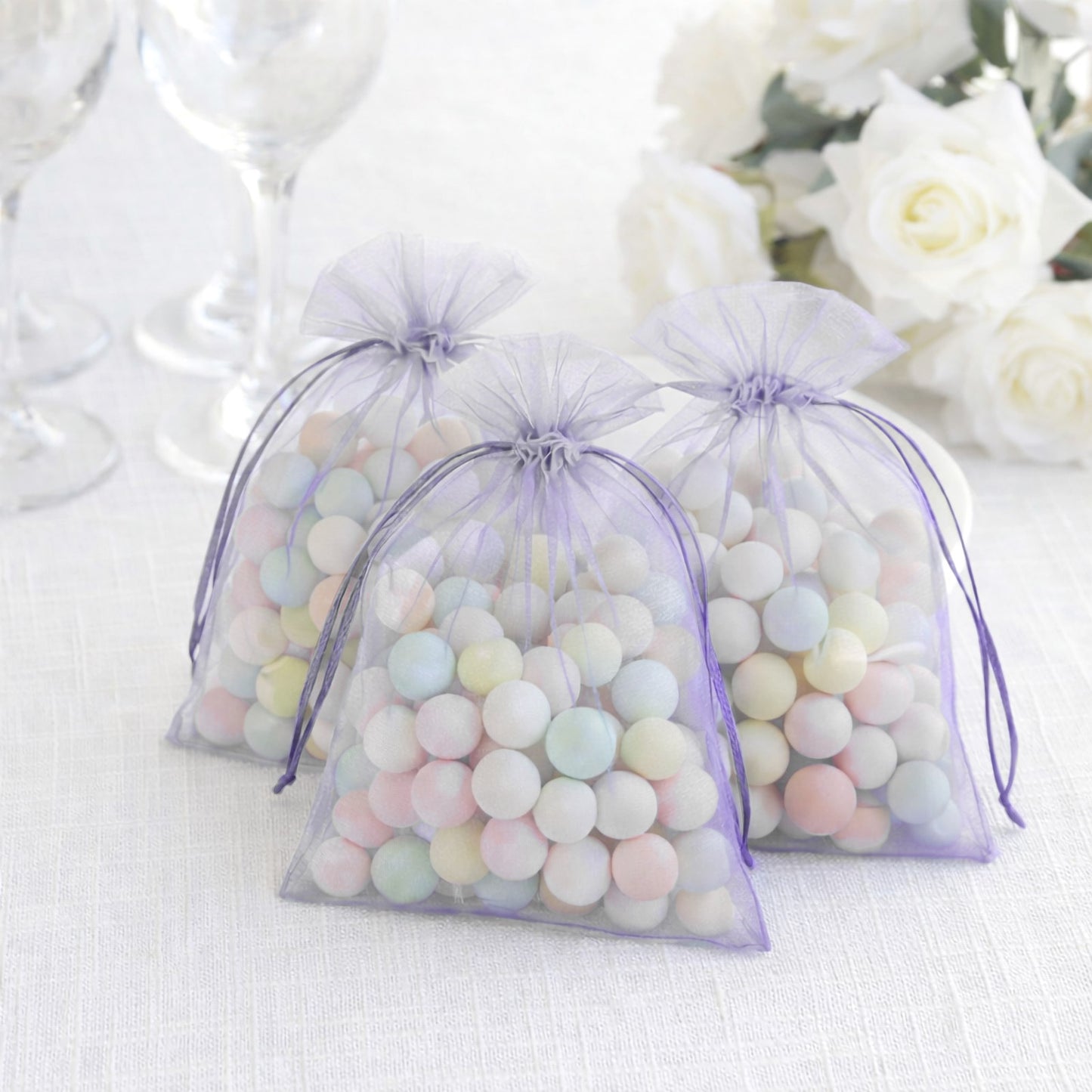 Lavender organza gift bags filled with pastel candies, perfect for party favors.
