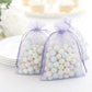 Lavender organza gift bags filled with pastel candies, perfect for party favors.