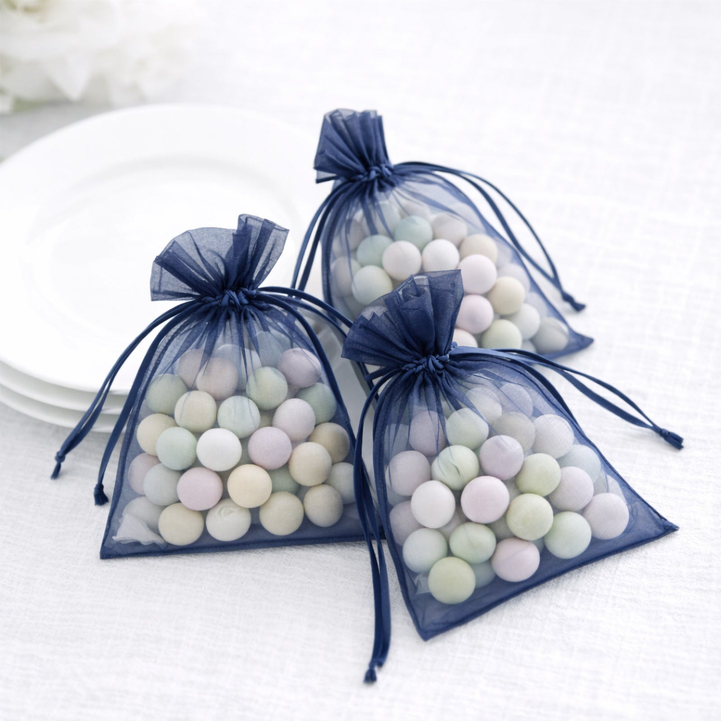 Navy blue organza gift bags with drawstring for party favors.