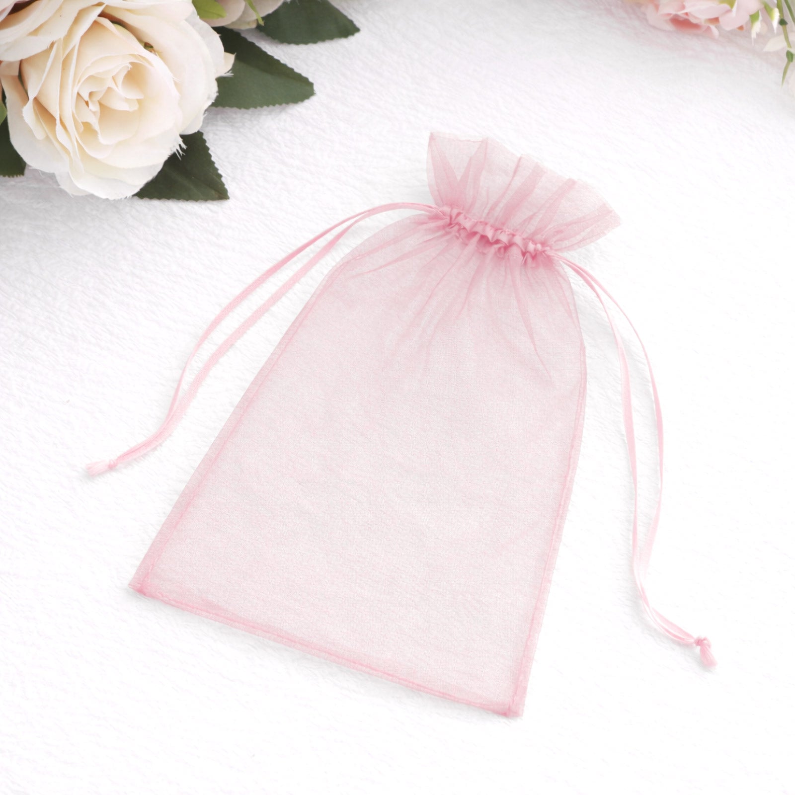 Pink organza gift bag with drawstring, perfect for wedding favors.