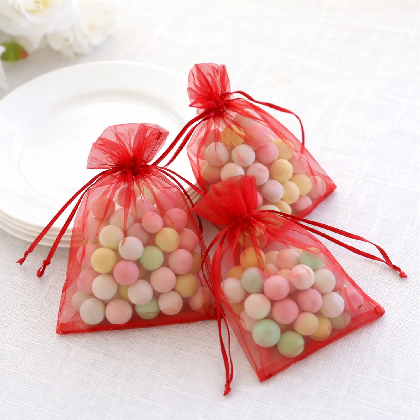 Red organza gift bags with drawstring, perfect for wedding favors.